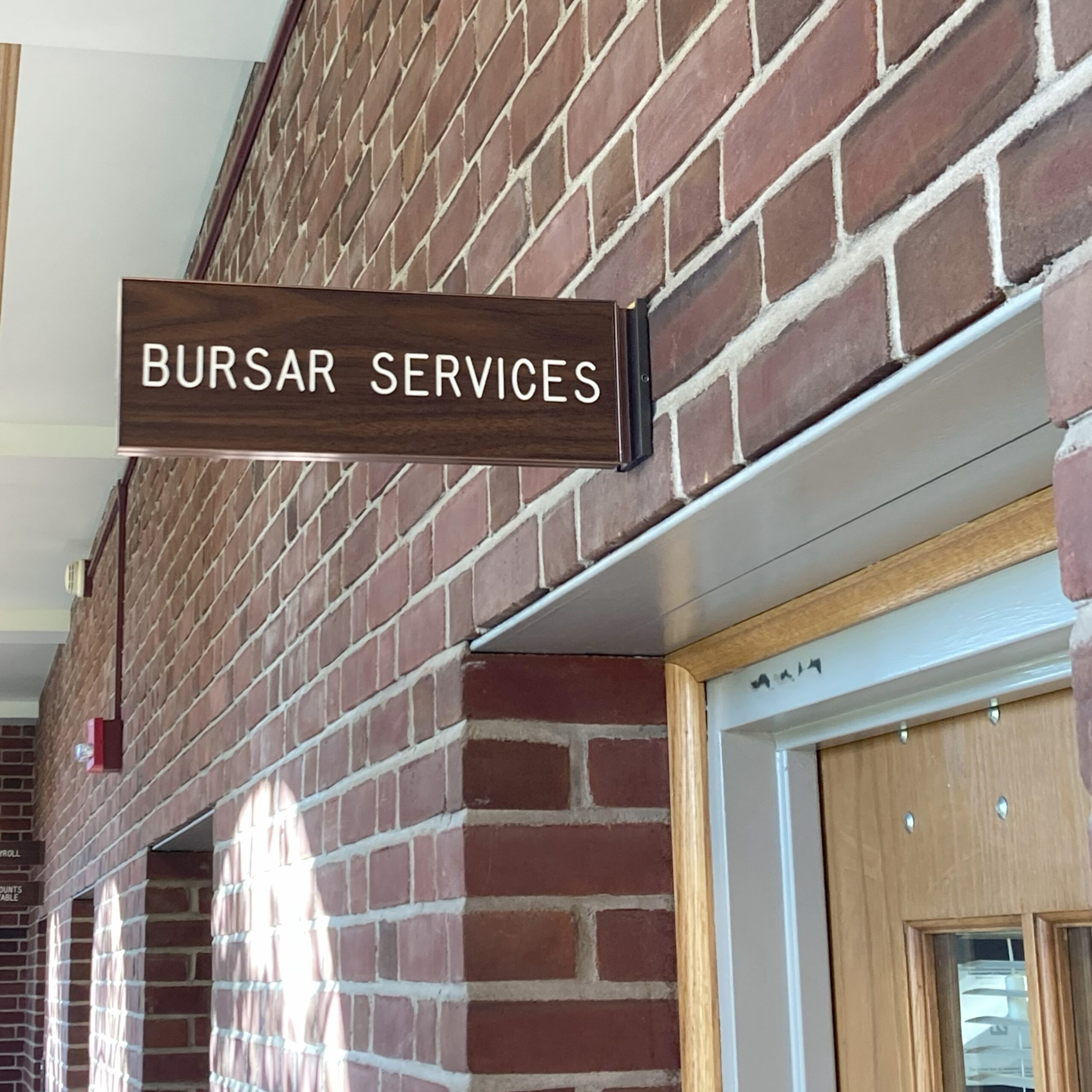 Bursar Services sign in college admin building.