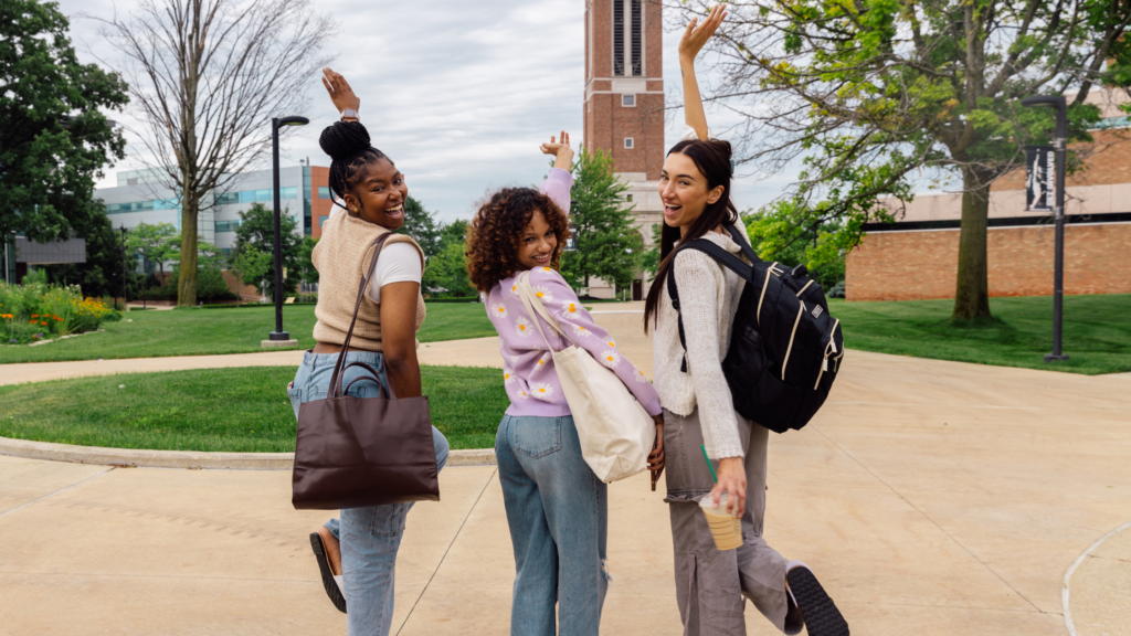 Three teen girls walking a college campus