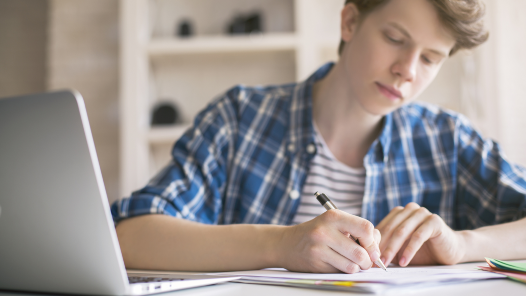 Young man working on his college application essay