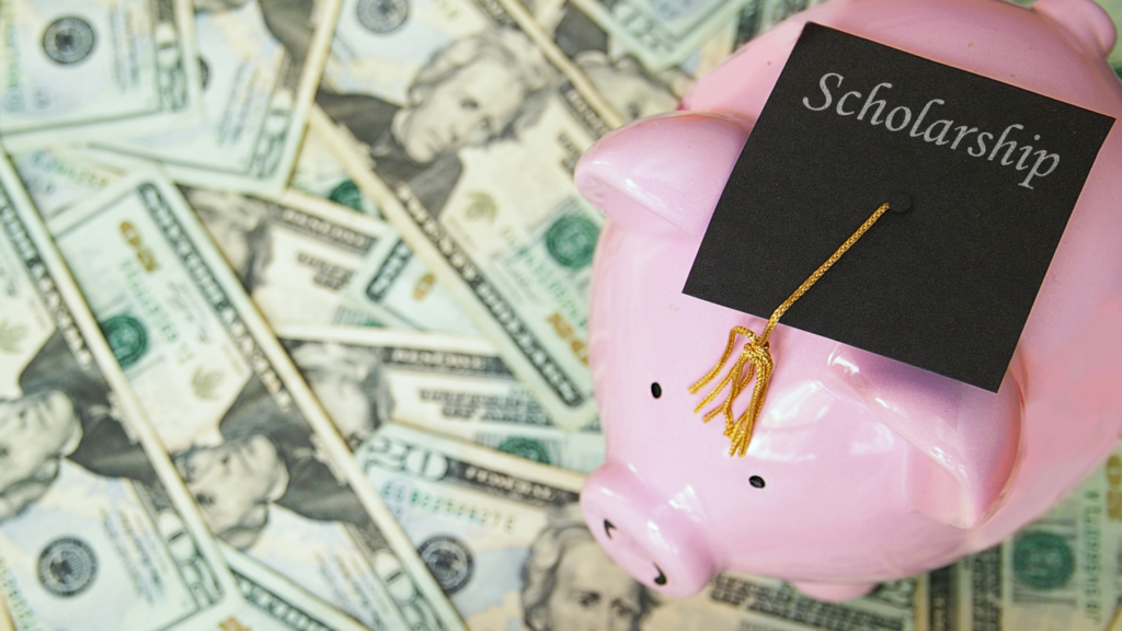 piggy bank with graduation cap and money representing a college scholarship
